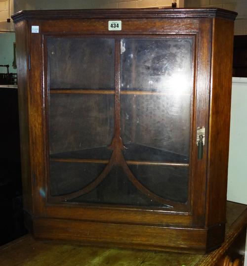 An early 20th century oak hanging Art Nouveau style corner cupboard, 58cm wide x 62cm high. L7