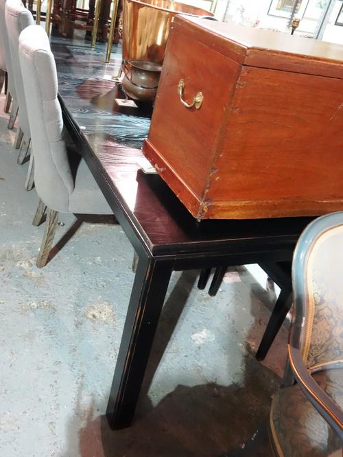 LOMBOK; A 20th century black painted ash extending dining table, with four extra leaves, inset with calligraphic inscribed plaques, 150cm wide x 85cm
