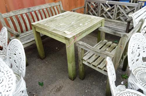 A 20th century hardwood square garden table, a matching open armchair and a bench, 140cm wide x 90cm high (3).  OUT