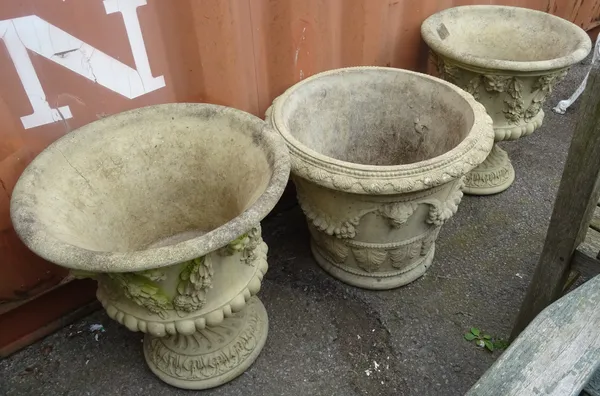 A pair of 20th century reconstituted stone garden urns, relief cast with swag and sash decoration and a similar planter, (3).  OUT