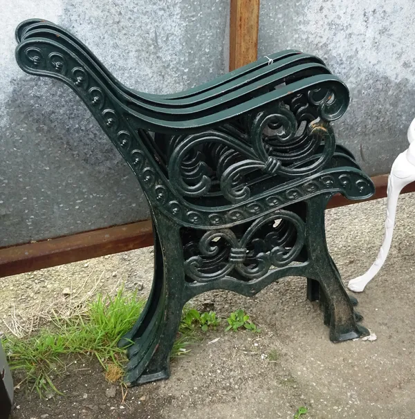 A pair of 20th century green painted bench ends with vine decoration and another pair, (4). OUT