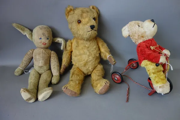 A straw filled teddy bear, circa 1950, possibly Chilterns, 39cm high, a teddy bear on a tricycle, and one further Merrythought 'Imp' straw filled char