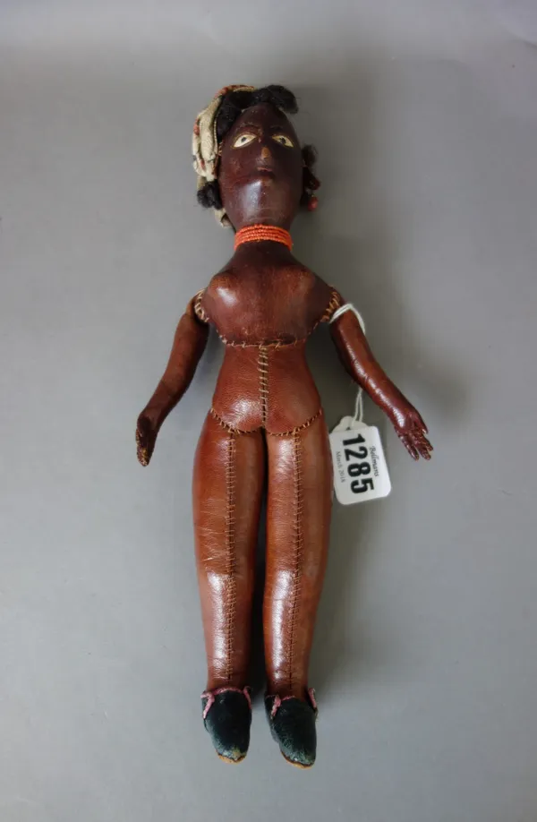 An ethnic leather doll probably Asian, early/mid 20th century, hand stitched leather, 27cm and a composite dolls head, possibly Japanese, (a.f) (2).