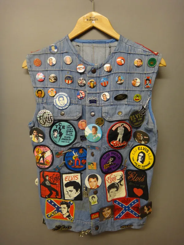 Elvis interest; a 20th century denim waistcoat, with applied badges, patches and pins, all relating to Elvis Presley.  Illustrated