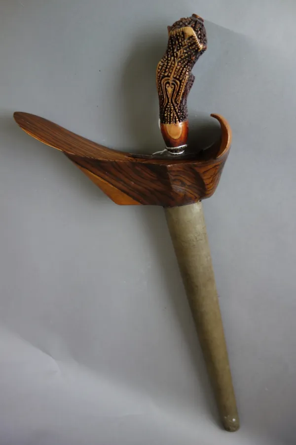 A Sumatran kris, with steel blade (35cm long), ornately carved wooden handle and a metal embossed wooden scabbard.