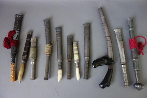An unusual South East Asian kris type knife, with a horn handle and white metal scabbard, 25.5cm long overall, together with ten further small knives,