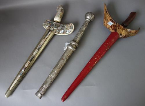 Two 20th century Sumatran kris, a South East Asian knife with white metal scabbard and handle, 42cm long, and an unusual wood and metal tethering spik