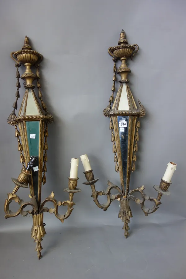 A pair of giltwood carved and mirrored two branch wall appliques, 20th century, with fluted urn finials (90cm high) and a pair of gilt metal Rococo st