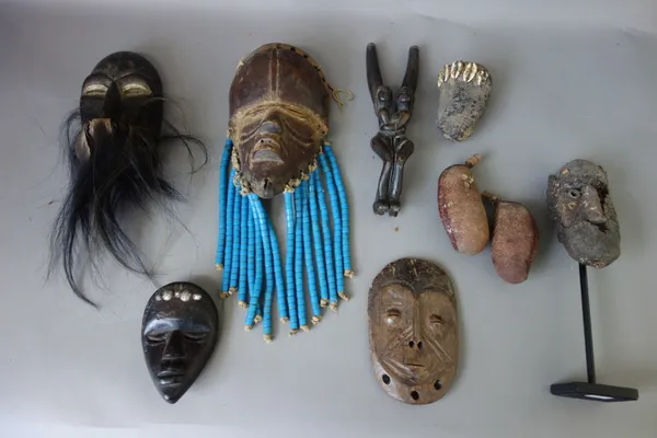 A quantity of African small wooden tribal masks, approximately 14cm high, an African head ornament, and related tribal items, (qty).