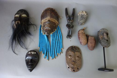 A quantity of African small wooden tribal masks, approximately 14cm high, an African head ornament, and related tribal items, (qty).