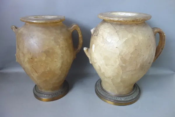 Two early 19th century alabaster jars, each of two handled form on a later gilt metal base, (a.f), 35cm high, (2).  Illustrated
