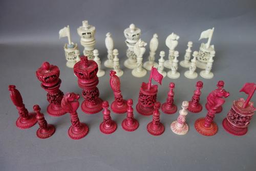 A Cantonese stained ivory chess set, early 20th century, of pierced foliate form, the king 10.5cm high.  Illustrated