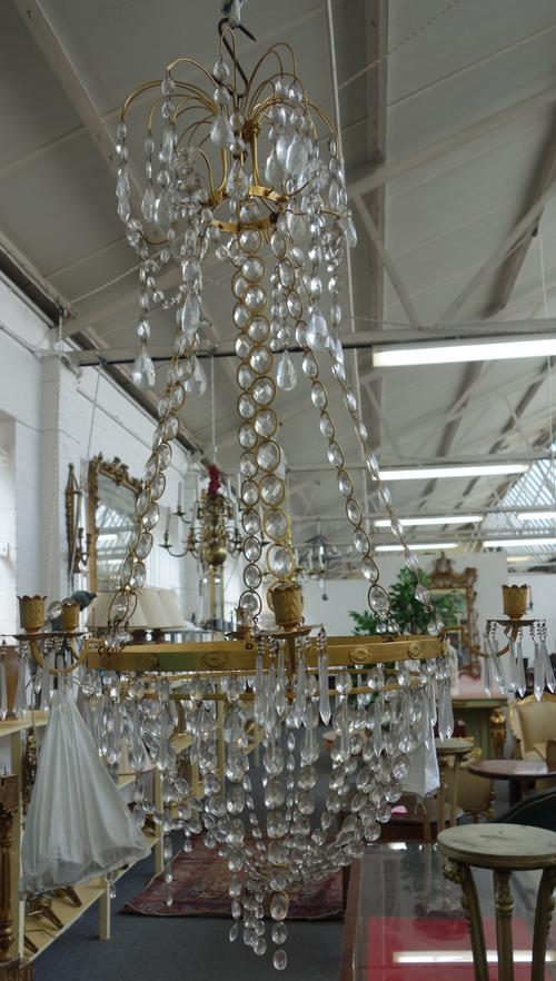 A North European ormolu and cut glass six light chandelier of Louis XVI style, 20th century, the three graduated circlets united by glass and ormolu c