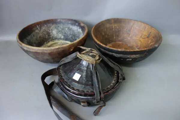 Four African wooden bowls with studded decoration, one 19th century, 39cm diameter, a tribal metal collar(?), an African leather food container, a ter