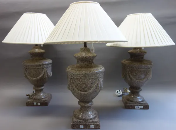 A set of three modern pottery table lamps, each faux marble design against an urn shaped body, with cream silk pleated shades, 45cm high excluding fit