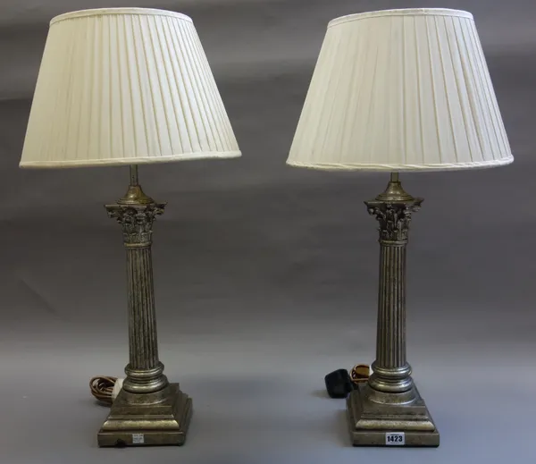 A pair of Victorian style gilt composite table lamps, modern, each of Corinthian column form, with cream silk pleated shades, the lamp 42cm high, (2).