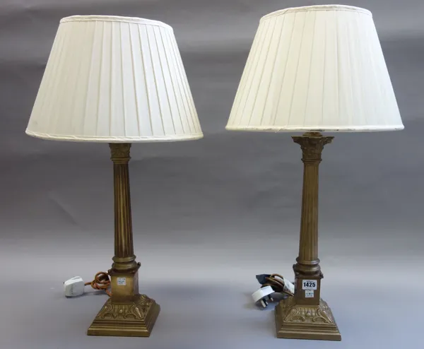 A pair of Victorian style brass table lamps, modern, each of Corinthian column form, with cream silk pleated shades, 44cm high, (2).