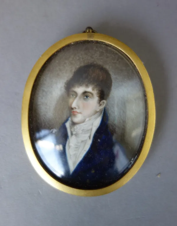 An early 19th century English School portrait miniature on ivory, of a young gentleman wearing a dark blue coat, white shirt and stock, the image 6.4c