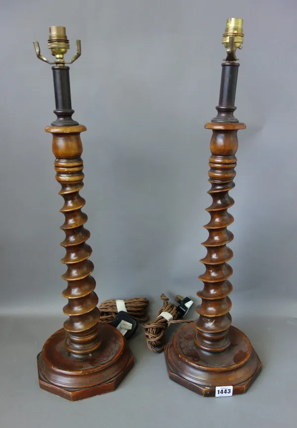 A pair of wooden spiral-twist table lamps, on octagonal bases, 48cm high, and a cylindrical copper and brass table lamp, with cream silk pleated shade