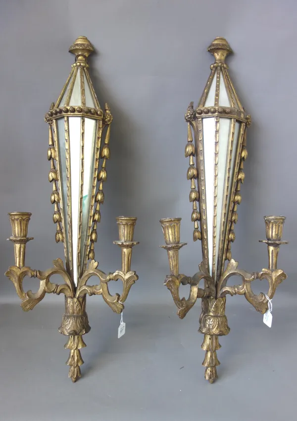 A pair of Victorian style giltwood two branch wall appliques, modern, each foliate carved with a sectional mirrored backplate, 80cm high, (2).