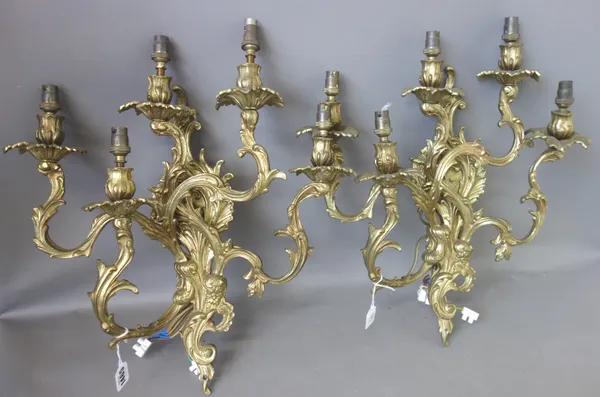 A set of five gilt brass Rococo style five branch wall appliques, modern, of foliate scroll form, the backplates 41cm high, (5).