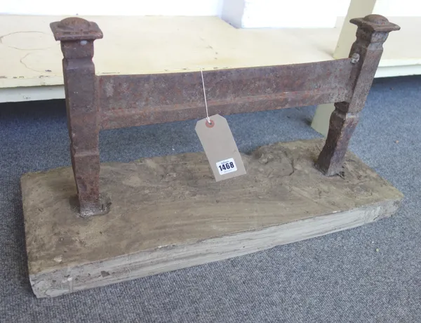 An early 19th century iron boot scraper, on rectangular stone base, the scraper 56ccm wide x 30cm high.
