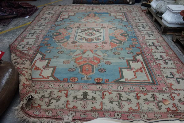 A Turkish carpet, the pale indigo field with large central medallion, ivory spandrels, an ivory border, 366cm x 273cm