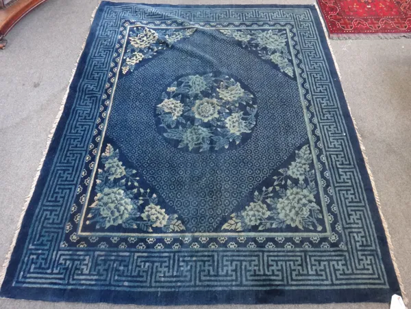 A Chinese rug, early 20th century, the blue field with circular central medallion in a fret cut border, 170cm x 212cm.