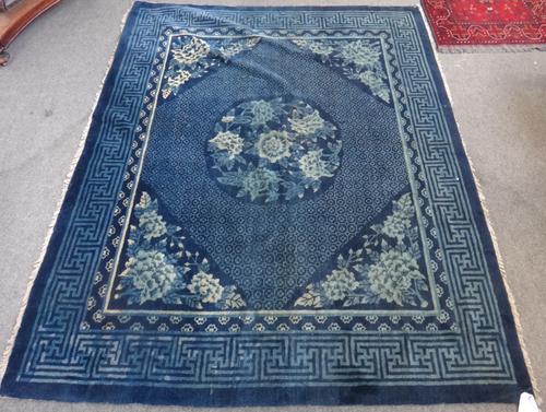 A Chinese rug, early 20th century, the blue field with circular central medallion in a fret cut border, 170cm x 212cm.