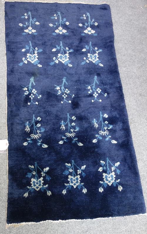 A group of three Chinese rugs, early 20th century, comprising; blue with flowers, 75cm x 142cm, blue and yellow with ponies, 68cm x 128cm, and brown w