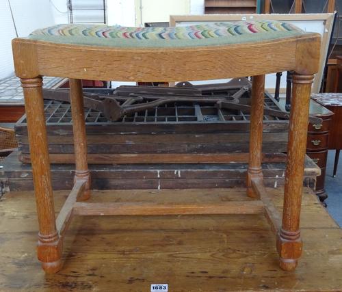 Probably Heals, a limed oak stool, the concave seat on turned supports, united by 'H' frame stretcher, 51cm wide x 46cm high x 38cm deep.