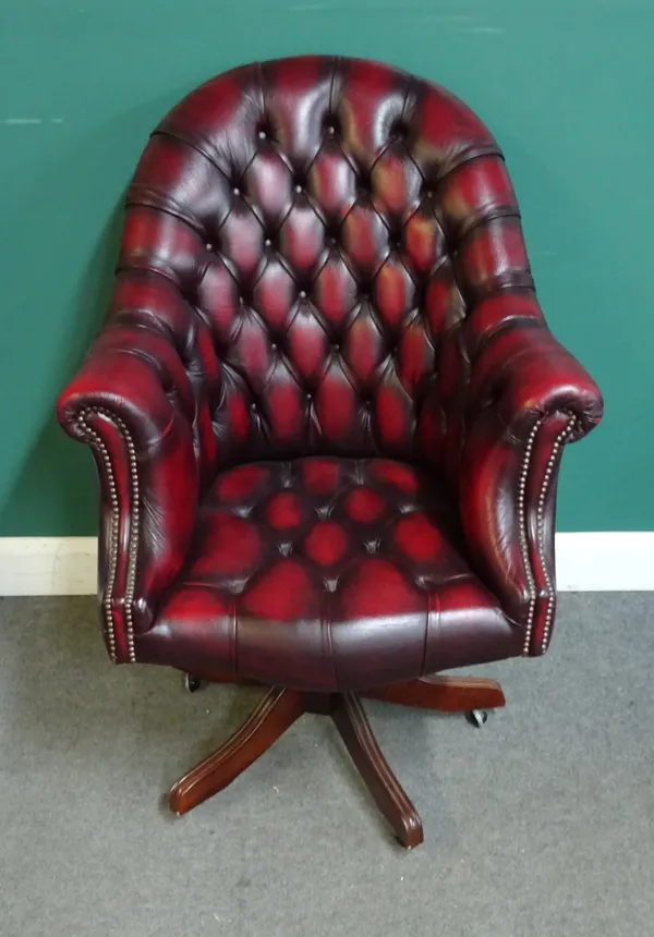 A 20th century office swivel chair, with brass button faux rouge leather upholstery, on a five point star base, 78cm wide x 115cm high.
