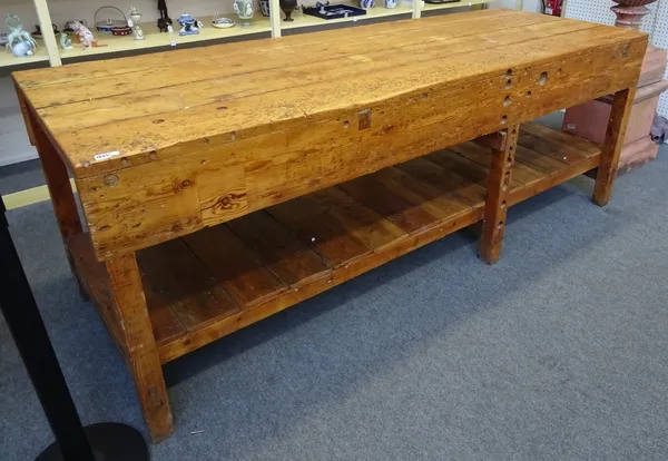 A 20th century waxed pine work bench, with plank top and undertier, on block supports, 244cm wide x 92cm high x 89cm deep.