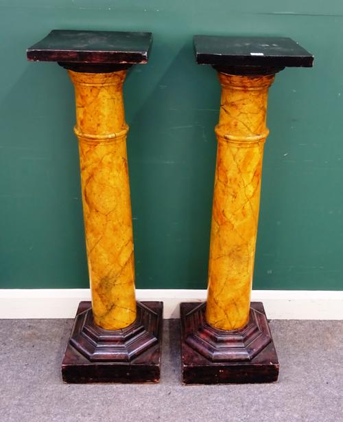 A pair of jardiniere stands, each with ebonised square top over faux marble painted column, on octagonal base, 35cm wide x 117cm high.
