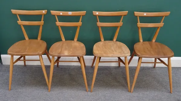 Ercol, a set of four beech and elm, green dot, stacking chairs, 40cm wide x 79cm high.