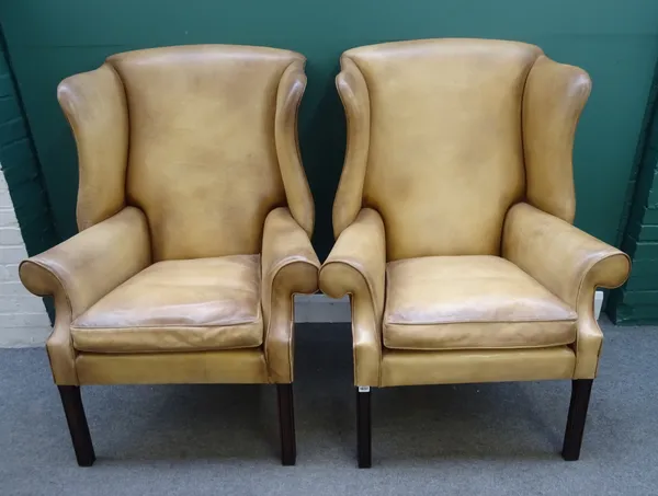 A pair of George II style leather upholstered wingback armchairs, on channelled square supports, 94cm wide x 23cm high.
