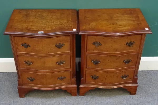 A pair of 20th century figured walnut and mahogany serpentine bedside cupboards, each of miniature chest form with three drawers, 47cm wide x 61cm hig