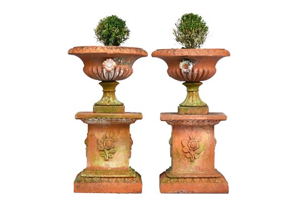 A pair of terracotta jardinieres, with egg and dart rim and fluted body, on stepped square pedestals, 49cm wide x 87cm high.  Illustrated