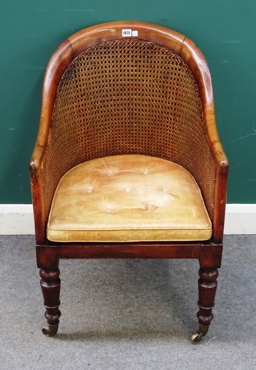 A William IV walnut framed tub back library bergere on turned supports, 55cm wide x 89cm high.