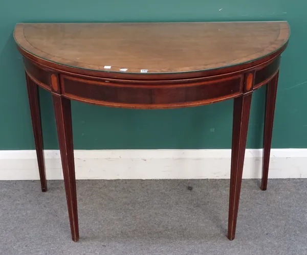 A George III mahogany and satinwood banded fold-over card table, of demi-lune form, hinged top over square tapering supports, with Scottish style arch