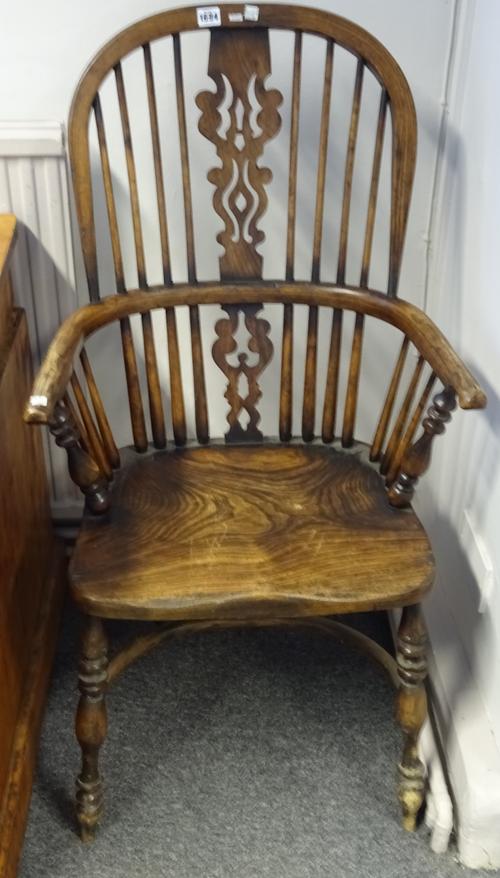 A pair of George III style elm and ash Windsor chairs, each with pierced splat and solid seat, on turned supports, united by crinoline stretcher, 50cm