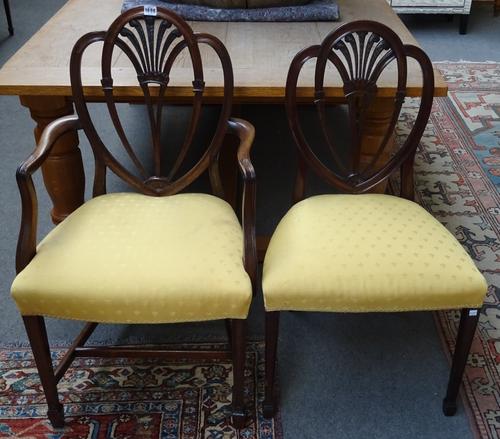 A matched set of twelve mahogany dining chairs, in the Hepplewhite manner, including a pair of armchairs, each with Prince of Wales feather spray with