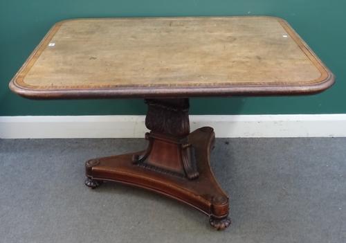 A Regency breakfast table, the satinwood banded mahogany rectangular snap top on carved triangular column and three melon carved feet, 123cm wide x 10