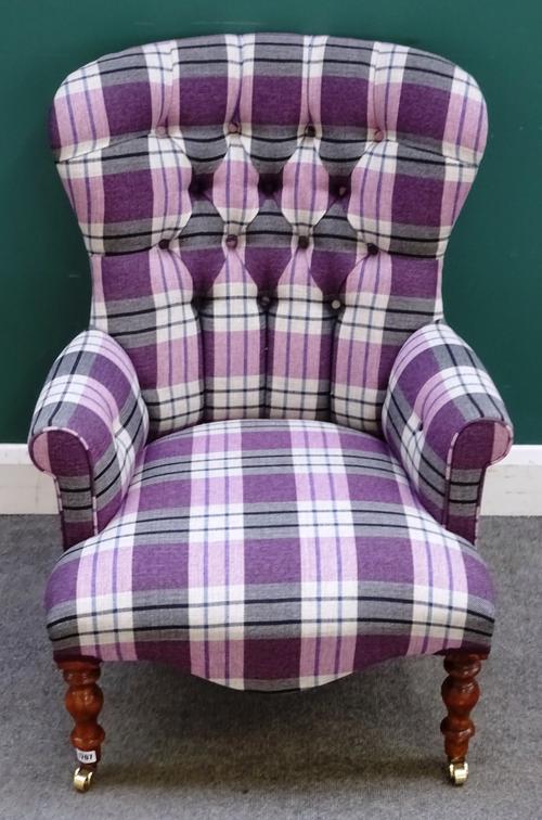 A modern button back easy armchair, with tartan upholstery and serpentine seat, on turned supports, 67cm wide x 92cm high.