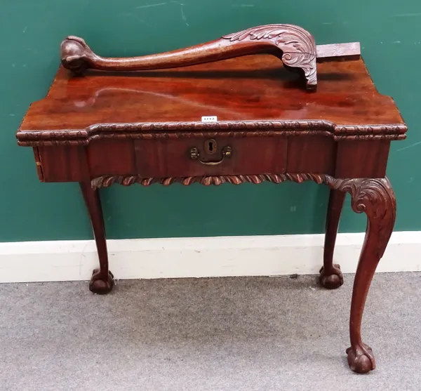 A carved George III mahogany card table, the re-entrant rectangular fold-over top above a frieze drawer, on cabriole supports, with claw and ball feet