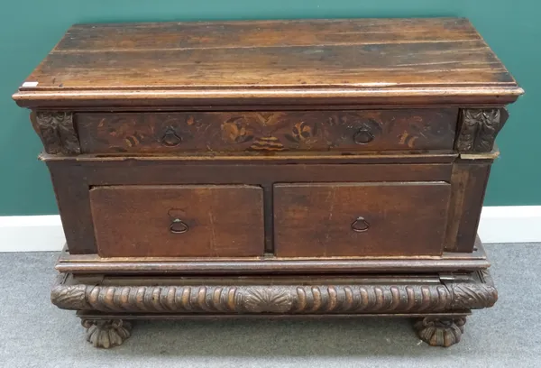 An 18th century Italian oak side cabinet, with one long and two short drawers and heavy gadrooned frieze, incorporating a secret drawer, on shaped bun