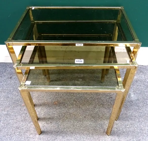 A nest of three smoked glass and lacquered brass rectangular occasional tables, on square supports, the larger 53cm wide x 43cm high x 37cm deep.