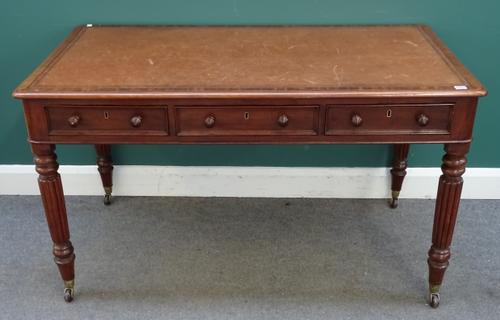 A William IV mahogany writing table, the rounded rectangular top with three frieze drawers, on reeded supports, 138cm wide x 75cm deep x 78cm high.