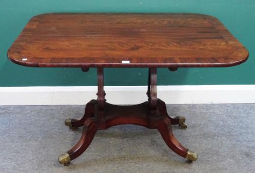 A Regency centre table, the rounded rectangular rosewood banded mahogany snap top, on a pair of lyre trestles and four downswept supports, 115cm x 91c