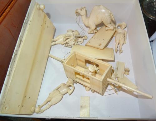 An Indian ivory figure group, 19th century, depicting figures carrying a carriage, and another similar group with a camel (a.f), the base 14cm wide, (